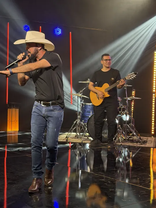 Tonny Ferrari em pé no palco com a banda